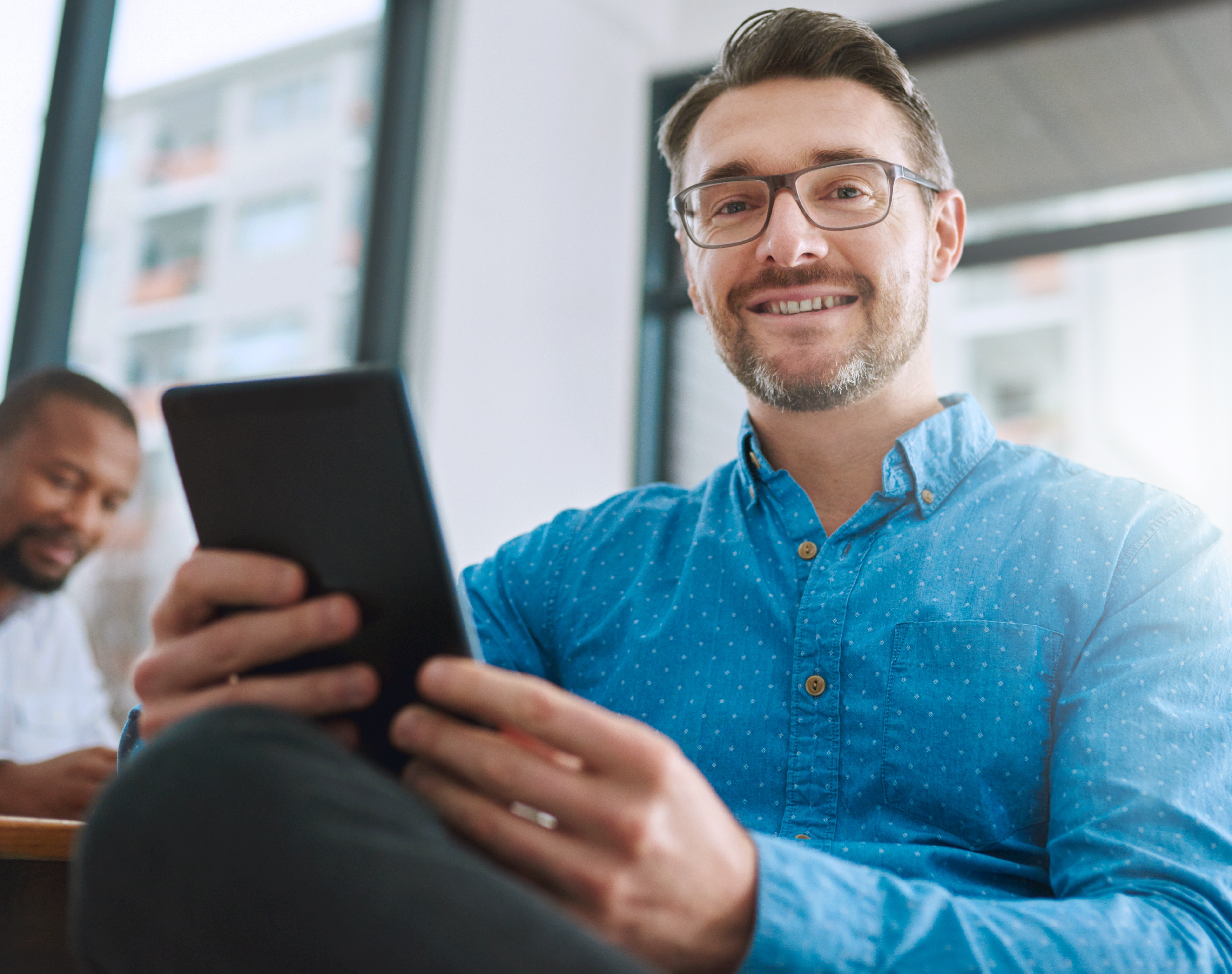 Hombre sonriendo con un celular en la mano 
